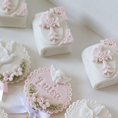 some small white and pink heart shaped cookies on top of a table next to each other