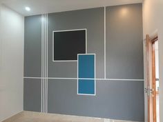 an empty room with grey walls and blue squares painted on the wall in different colors