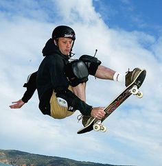 a man flying through the air on top of a skateboard next to another man