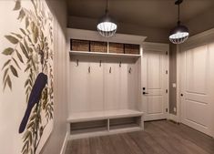 an empty entryway with two benches and baskets on the wall, along with hanging lights