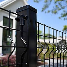 a black fence with a house in the background