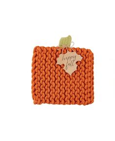 an orange crochet purse with a tag on the front and a green leaf hanging from it