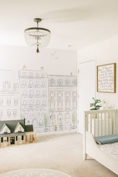 a baby's room with a crib and wall mural