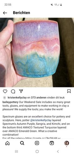 someone is holding up a small bowl in their hand, which has been painted with different colors