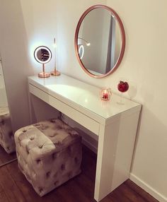 a white vanity table with a mirror and stool in front of it on top of a hard wood floor