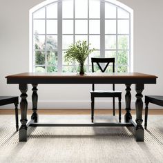 a dining room table with two chairs and a potted plant in the middle on top