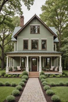 a house that is in the middle of some grass and trees with bushes around it