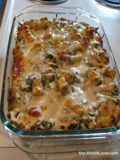 a casserole dish with cheese and spinach in it on a counter top