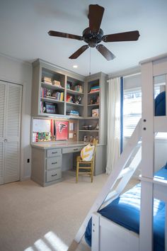 a bedroom with two bunk beds, a desk and a ladder to the top of it