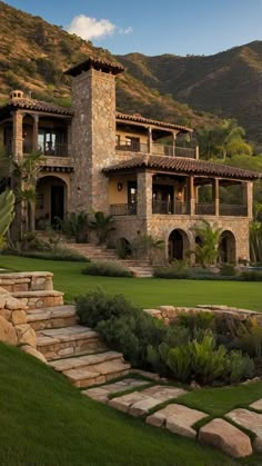 a large stone house with steps leading up to it's front entrance and landscaping