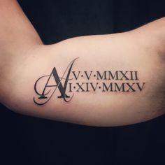 an arm tattoo with roman numerals and the letter m on it's side