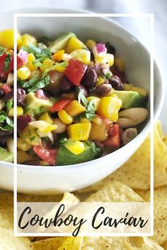 a white bowl filled with black bean and corn salsa surrounded by tortilla chips