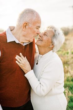 an older couple embracing each other in a field