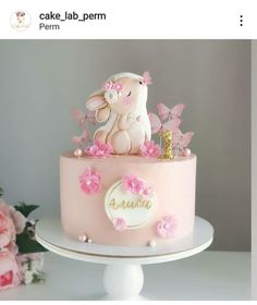 a pink cake decorated with an elephant and flowers