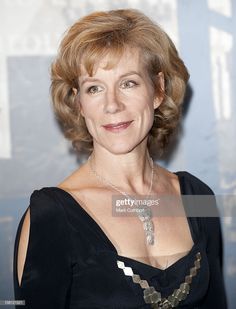 a woman in black dress posing for the camera with a necklace on her neck and chest