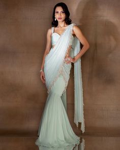 Mint georgette fishtail sari featuring an attached pre-draped pallu hand embellished with ivory pearls & glass beads & tassles. Paired with a stylised organza crop with embellished straps & an oversized bow at the back.From Shloka Khialani's Winter Sun collection.DELIVERY TIMEPlease allow 6-8 weeks for your outfit to arrive.FABRIC DETAILSGeorgette, Organza, CrepeProfessional cleaning only. Hand Embellished Georgette Pre-draped Saree, Designer Draped Hand Embellished Saree, Hand Embellished Georgette Saree With Draped Design, Designer Hand Embellished Draped Saree, Hand Embellished Georgette Pre-draped Saree For Reception, Hand Embellished Georgette Pre-draped Saree For Wedding, Party Wear Pre-draped Saree With Pearl Embroidery For Reception, Wedding Hand Embellished Georgette Pre-draped Saree, Hand Embellished Pre-draped Saree For Reception