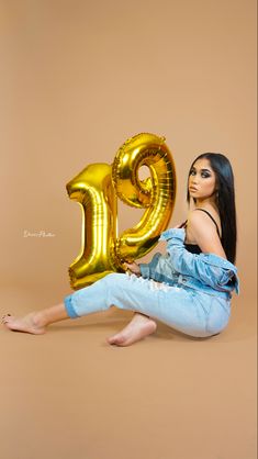 a woman sitting on the floor with her legs crossed and holding an inflatable balloon