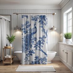 a blue and white shower curtain with a bird on it in a bathroom next to a tub