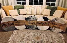 a living room filled with lots of furniture and pillows on top of a rug next to a window