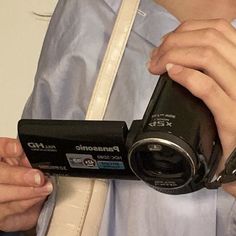 a person holding a camera in their hand and taking it off the strap to take pictures