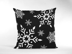 a black and white pillow with snowflakes on it