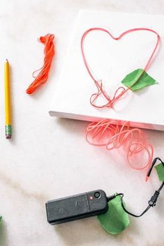 a heart shaped piece of paper next to a pencil and some other crafting supplies