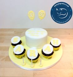 a birthday cake and cupcakes on a yellow plate