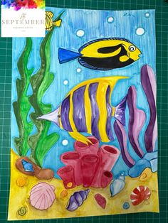 an art project with watercolors on paper and colored pencils, including fish