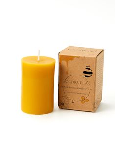 a yellow candle sitting next to a cardboard box