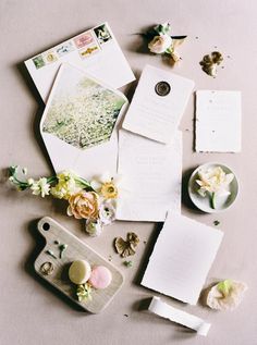 an assortment of papers and flowers on a table