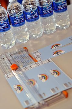 several bottles of water sitting on top of a table next to a binder and ruler