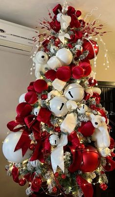 a red and white christmas tree with teddy bears on it's branches, ornaments and lights