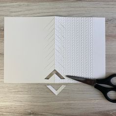 a pair of scissors cutting paper on top of a piece of white paper with lines