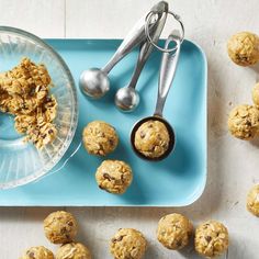 cookies and spoons on a blue tray next to a bowl of oatmeal