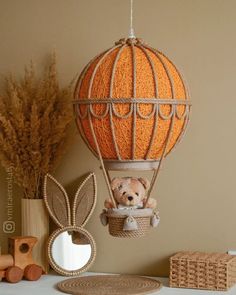 a teddy bear in a hot air balloon hanging from the ceiling next to a mirror