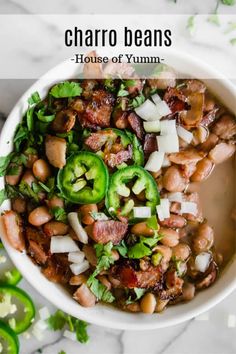 a white bowl filled with beans, onions and jalapenos on top of a table