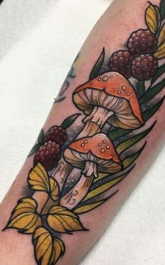 a tattoo with mushrooms and berries on it