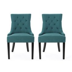 pair of teal velvet dining chairs with dark wood legs and tufted upholstered backrests