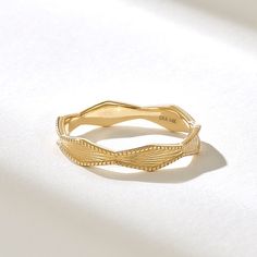 a close up of a gold ring on a white surface