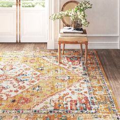 an orange and yellow area rug in front of a door with flowers on the side