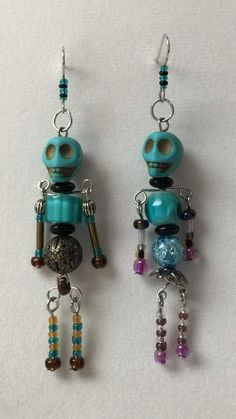 two earrings with beads and charms hanging from them