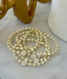 - Beautiful dainty pearl initial bracelet that makes a gorgeous bracelet gift. Soft and delicate with tiny 18 gold filled beads and freshwater shell initial bead. Coordinating pieces in shop. Beaded on high quality stretch cord and secured. - 3mm 18k gold filled beads   4mm mother of pearl beads    8mm freshwater shell initial bead. - Purchase is sent in a white velvet drawstring jewelry bag, making the perfect bracelet gift for bridesmaid, bracelet for mom, anyone special or just yourself. - To care for your bracelet, please roll on and off wrist. Repeated stretching can wear the elastic over time. Avoid excessive contact with water and chemicals. - We highly recommend measuring your wrist before ordering. Please see our sizing guide in the listing photos.  - We strive to get orders out a Bridesmaid Bracelet Gift, Bracelet Initial, Gold Armband, Gold Bead Bracelets, White Velvet, Bridesmaid Bracelet, Initial Bracelet, Gorgeous Bracelet, Jewelry Bags