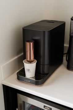 an espresso machine sitting on top of a counter next to a coffee maker