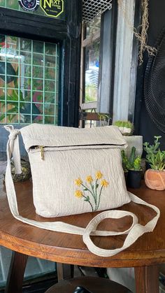 a white purse sitting on top of a wooden table