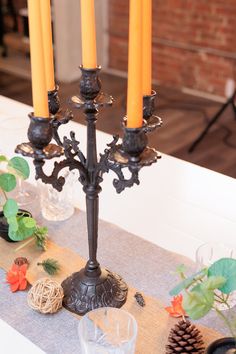 a candelabra with three candles on it sitting on a dining room table