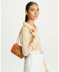 Small Eleanor Leather Shoulder Bag is the perfect accessory to carry your essentials in stylish simplicity. With gusseted sides and a snap closure, this petite bag keeps your items organized while its calfskin leather exterior and gold-tone hardware lend understated sophistication. Adjust the rope chain strap for versatile wearing or carry it doubled for a shorter look. Interior features include a zip and slip pocket to safely secure your phone, wallet and more. At just 7.5' wide, it fits comfor Tory Burch Shoulder Bag, Womens Designer Handbags, Favorite Handbags, Tory Burch Bags, Designer Shoulder Bags, Tory Burch Bag, New Wardrobe, Online Bags, Rope Chain