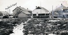 an old black and white photo of houses with snow on the ground in front of them