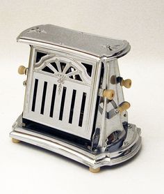 a small silver clock sitting on top of a table