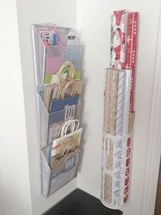 a stack of books and magazines hanging on a wall next to a door with wrapping paper