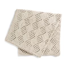 two white knitted blankets sitting on top of each other